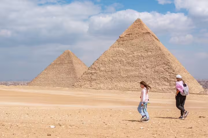 Travelers walking by the Giza Pyramids on a shore excursion from El Sokhna Port to Cairo and the GEM