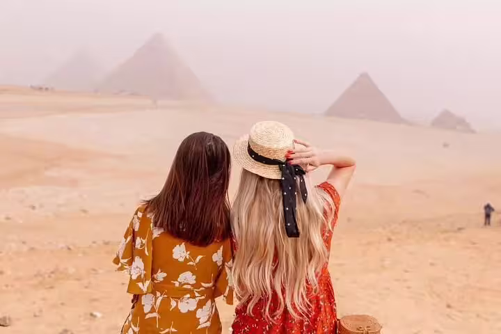 Travelers watching the Giza Pyramids in the Sahara on a 3-hour private tour to pyramids and Sphinx