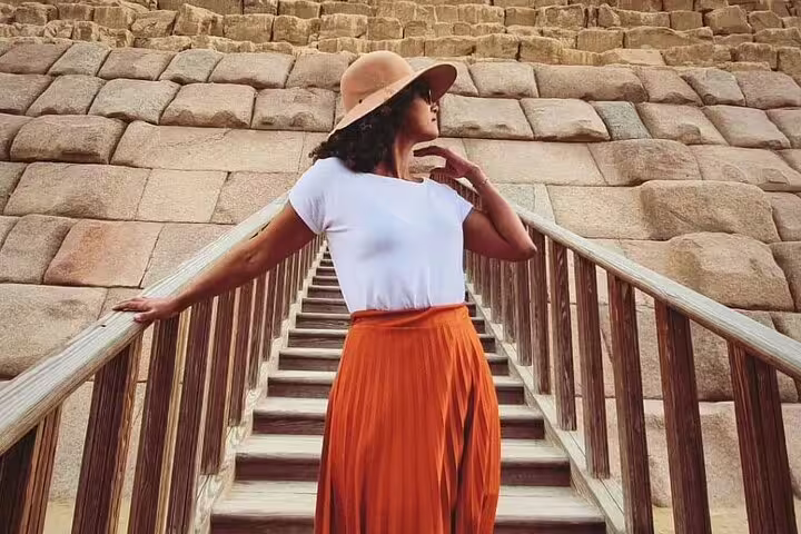 Visitor on stairs beside the Great Pyramid of Giza stones, private guided tour with transfers and entry tickets