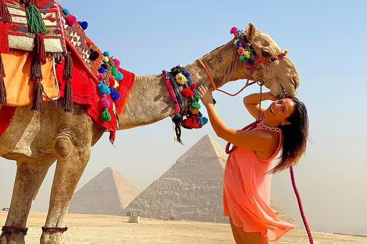 Private camel tour at Giza Pyramids, traveler with decorated camel in Egypt desert near pyramids