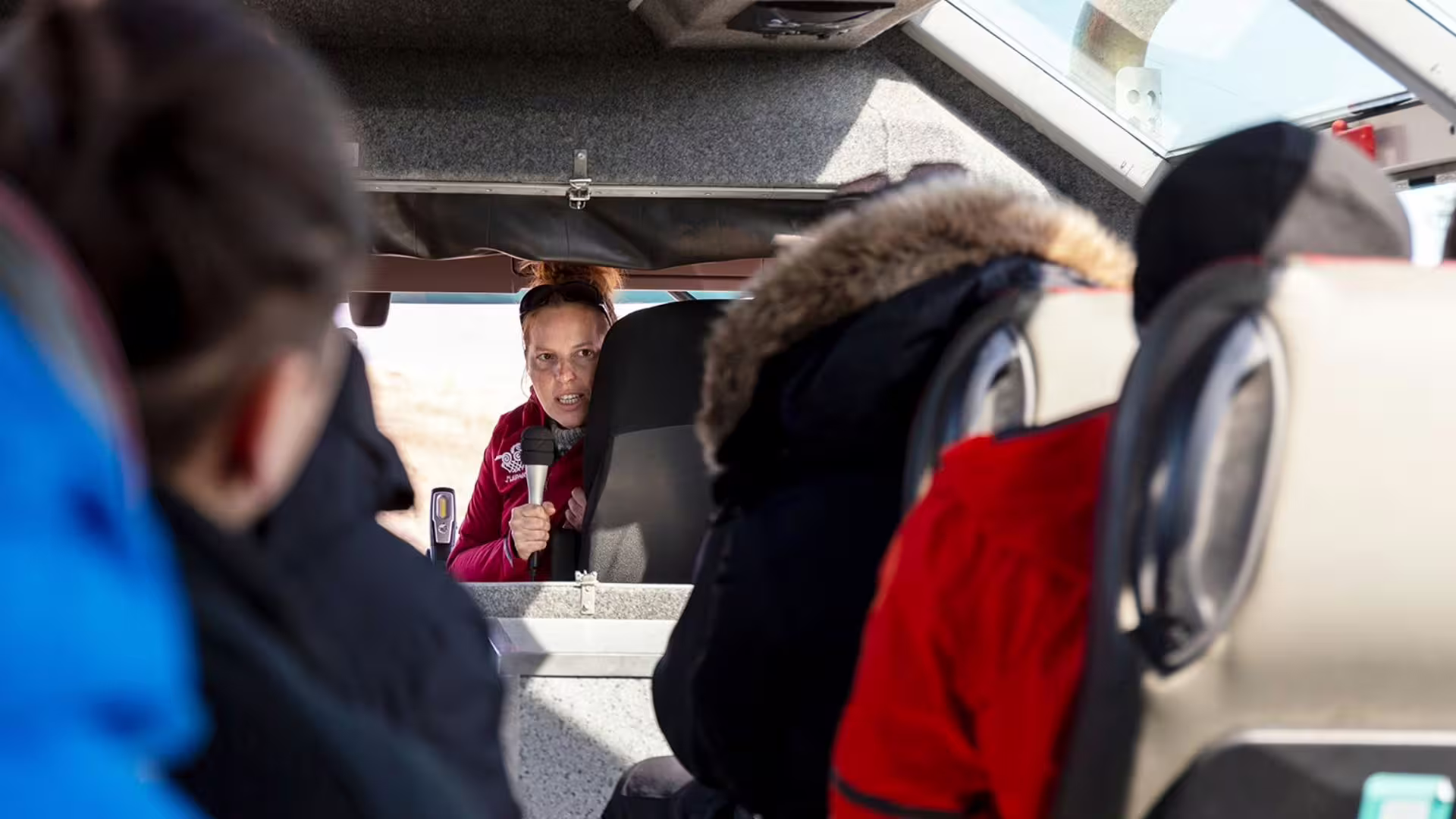 Guide briefing passengers inside Glacier Monster Truck on the ice cave and glacier tour from Gullfoss