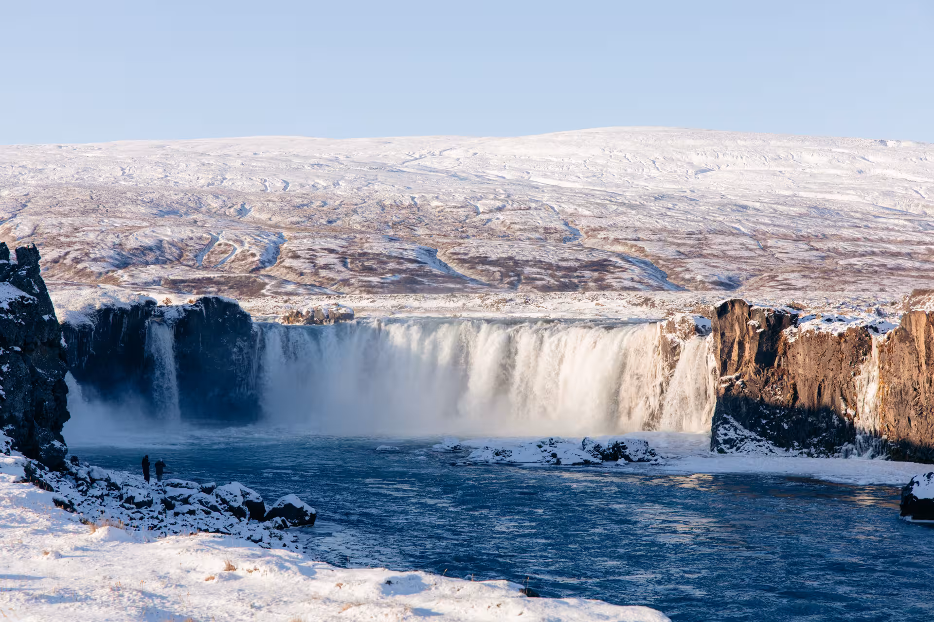 Goðafoss Waterfall in winter, North Iceland, on Northern Wonders tour with snowy cliffs and blue river