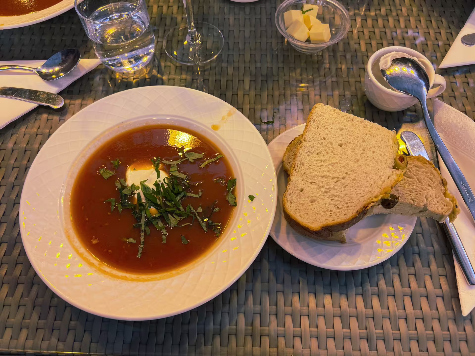 Hearty tomato soup garnished with herbs alongside fresh bread, part of the Friðheimar feast on the Golden Circle Adventure tour.