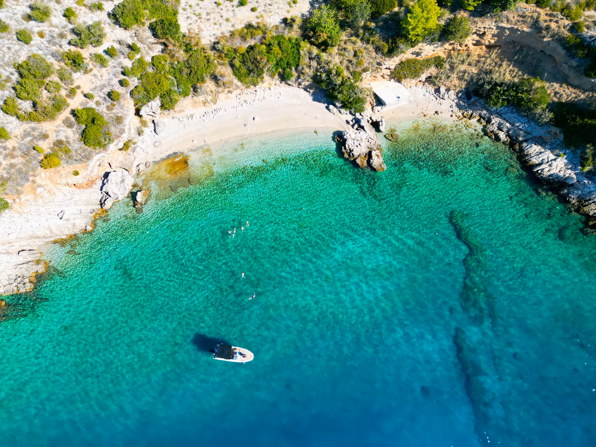 Aerial view of a secluded Brač Island bay with turquoise water and speedboat stop on Golden Horn tour