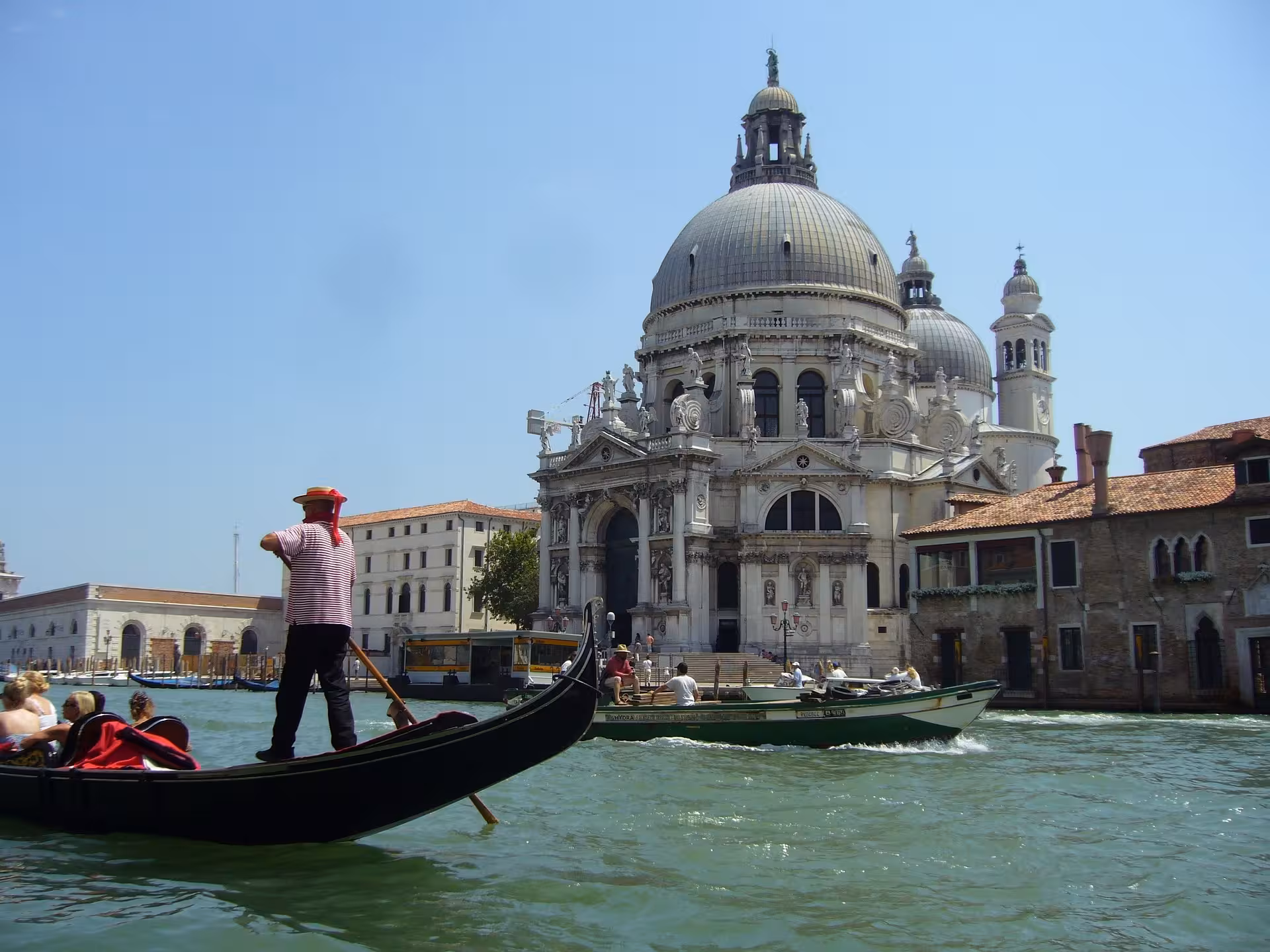 Gondolier navigating the waters near the iconic Santa Maria della Salute in the heart of Venice.
