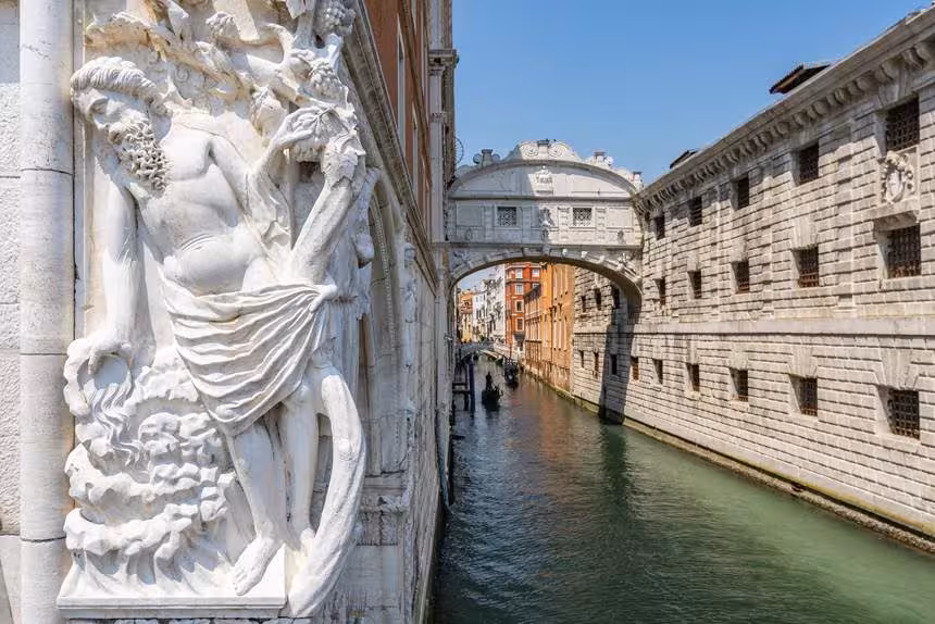 View of the Bridge of Sighs over a tranquil canal in Venice, perfect for a shared gondola ride experience.