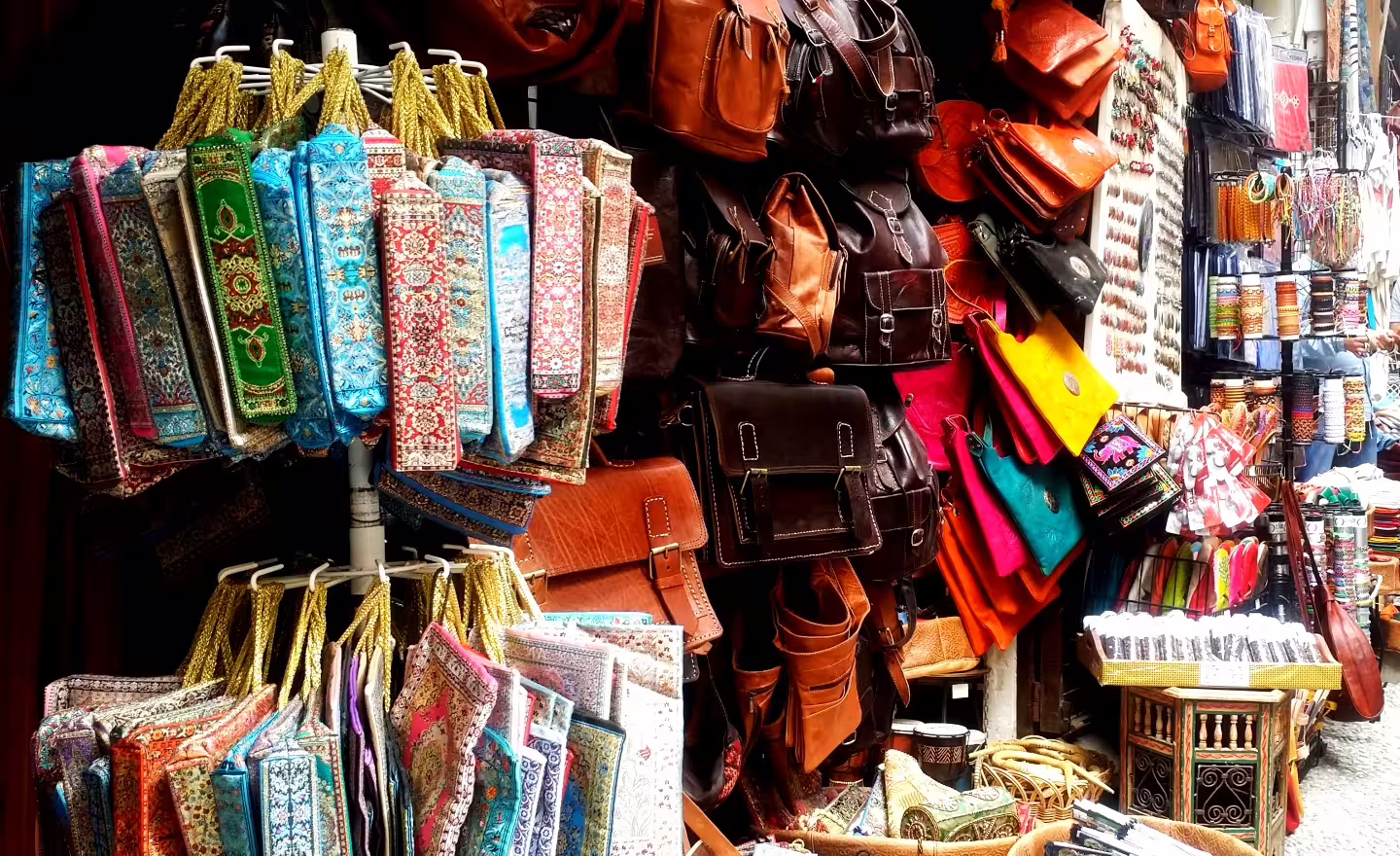 Colorful Granada market stall with leather bags and souvenirs, perfect add-on to Alhambra private day trip