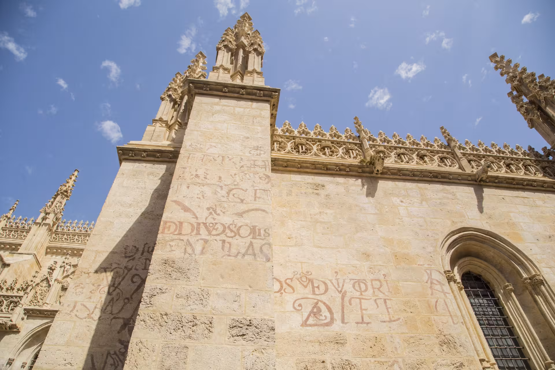 Intricate Gothic architecture of Granada's Royal Chapel against a blue sky, must-see on free Granada tours.