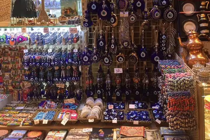 Grand Bazaar Istanbul stall with evil eye souvenirs and Turkish jewelry, shopping stop on 12-day Turkey tour