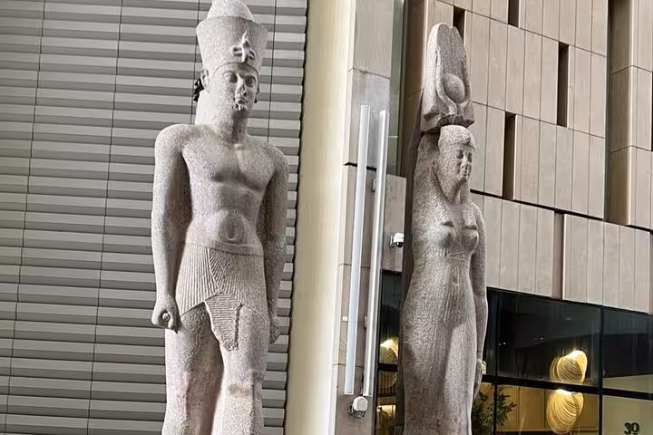 Grand Egyptian Museum Cairo entrance statues on a private guided tour, modern facade and ancient guardians