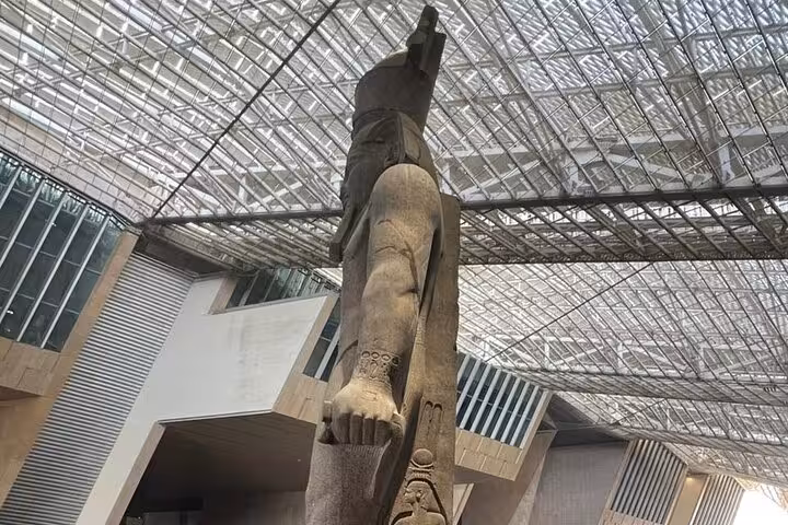Colossal ancient Egyptian statue in the Grand Egyptian Museum atrium on a private guided Cairo tour