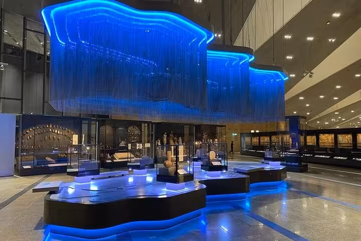 Modern Grand Egyptian Museum gallery with illuminated displays, key stop on Giza Pyramids and Sphinx tour