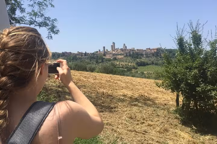 Traveler photographing the stunning skyline of San Gimignano during Tuscany tour.