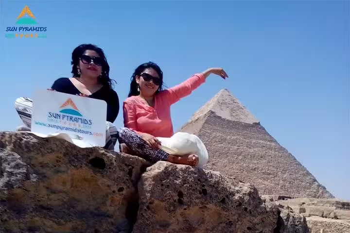 Tourists posing by the Great Pyramid of Giza on Cairo day tour to Memphis, Saqqara and Dahshur pyramids