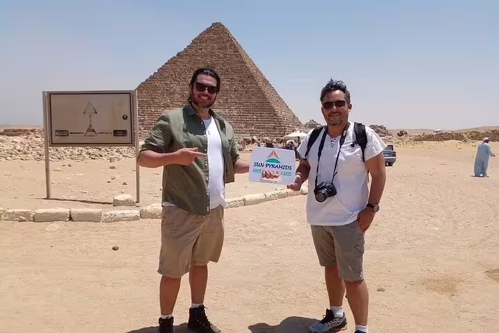 Tourists pose by the Great Pyramid of Giza on a Cairo day tour from Alexandria with private guide
