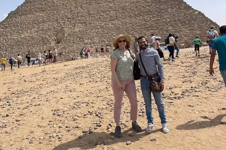 Tour guests pose by the Great Pyramid of Giza on a private pyramids and Sphinx adventure tour in Cairo
