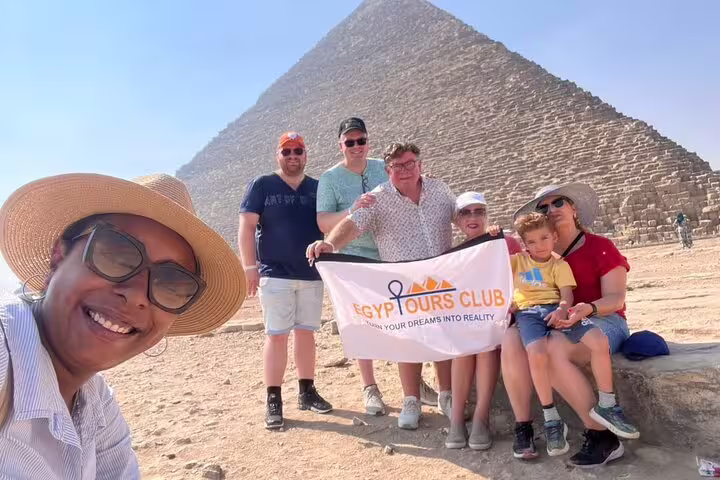 Happy group photo at Great Pyramid of Giza on half-day pyramids tour with local guide and family