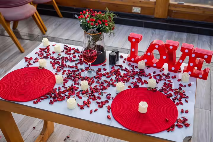 Close-up romantic setup at Great Pyramid Inn with LOVE sign, rose petals and lunch table on rooftop