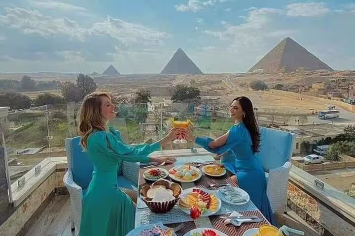 Guests enjoy rooftop lunch at Great Pyramid Inn with panoramic Giza Pyramids view and fresh dishes