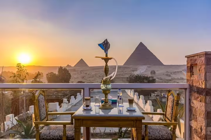 Rooftop table with shisha at Great Pyramid Inn during sunset lunch, overlooking the Giza Pyramids