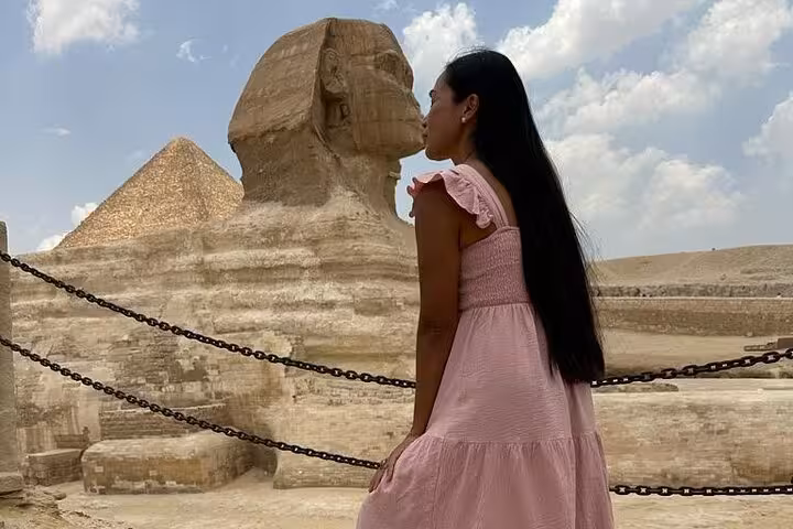 Visitor viewing the Great Sphinx with Pyramid of Khafre behind on a half-day private Giza pyramids tour