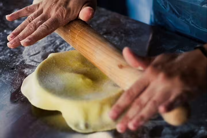 Hands rolling filo dough in an Athens Greek cooking class before rooftop dinner with Acropolis view