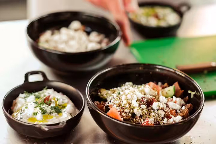 Greek cooking class in Athens: fresh village salad and tzatziki bowls prepared for rooftop dinner with Acropolis view