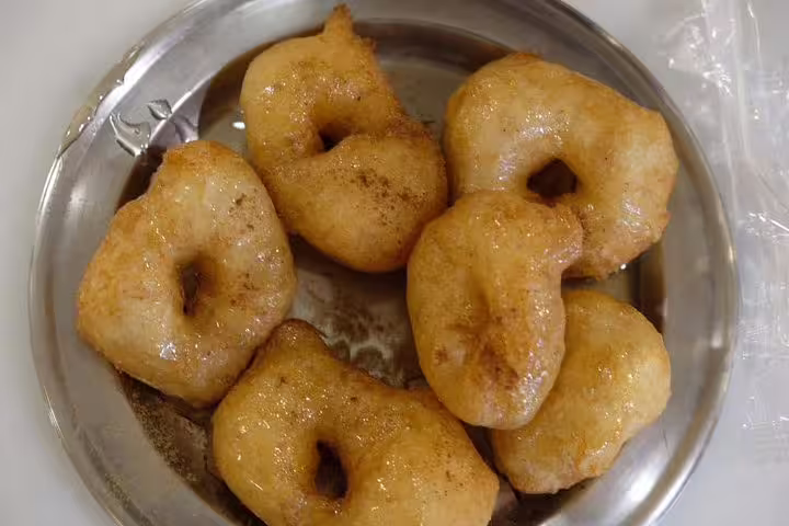 Close-up of Greek loukoumades donuts glazed with honey and cinnamon, dessert tasting on Athens food tour