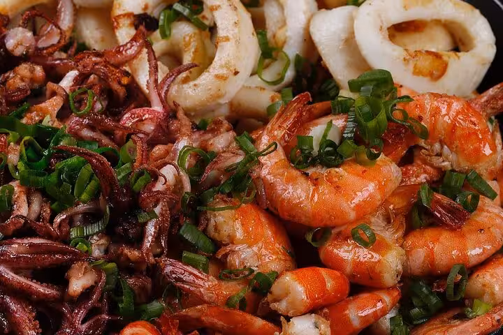 Grilled seafood platter with shrimp and calamari garnished with fresh herbs for Brazilian BBQ dinner in Rio.