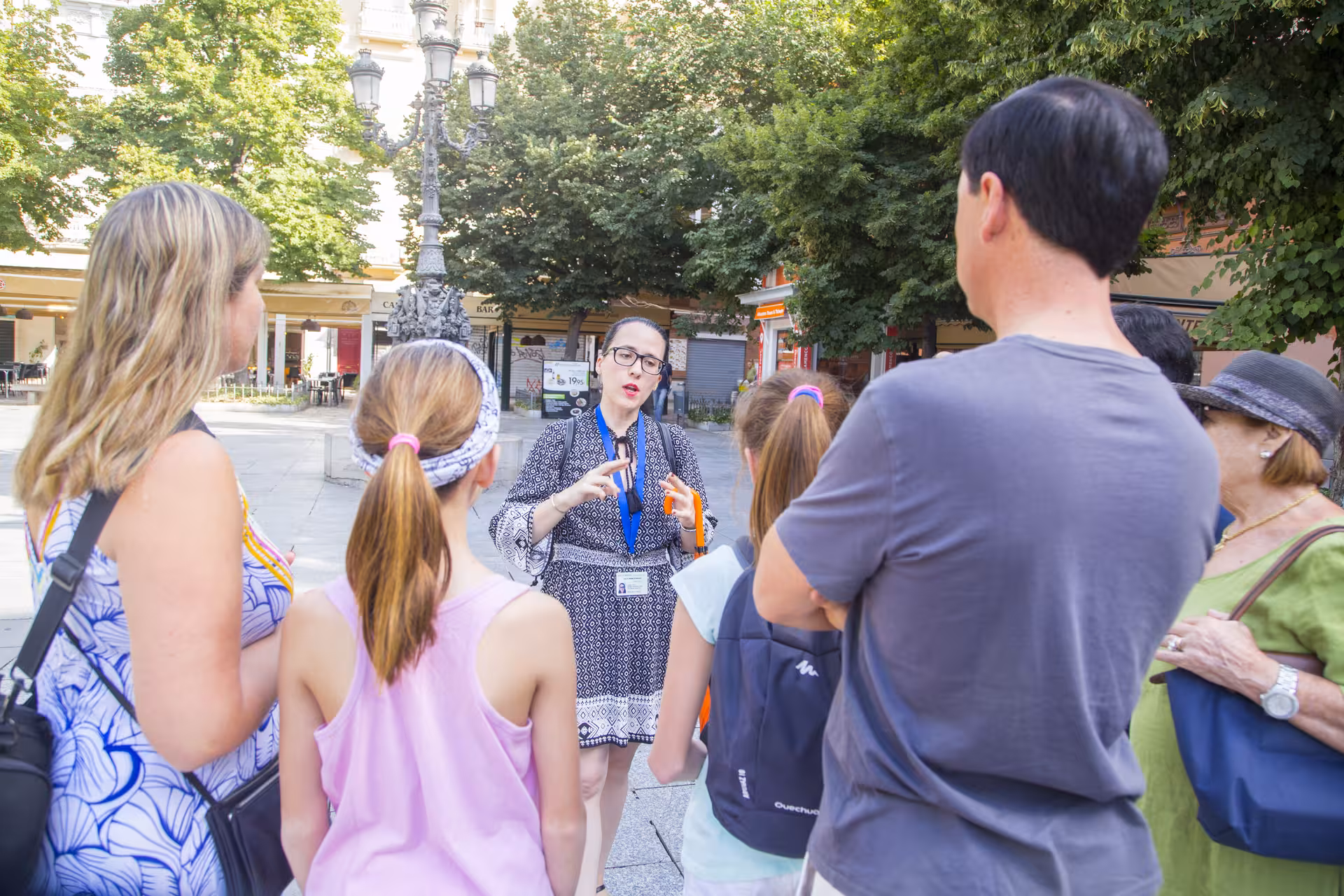 Tour guide engaging with a group of tourists in a vibrant city square, part of a guided cathedral tour experience.