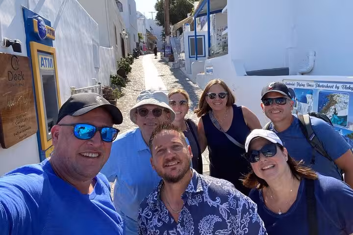 Travel group walking Mykonos whitewashed alley, guided experience on 7 days Athens Mykonos Santorini