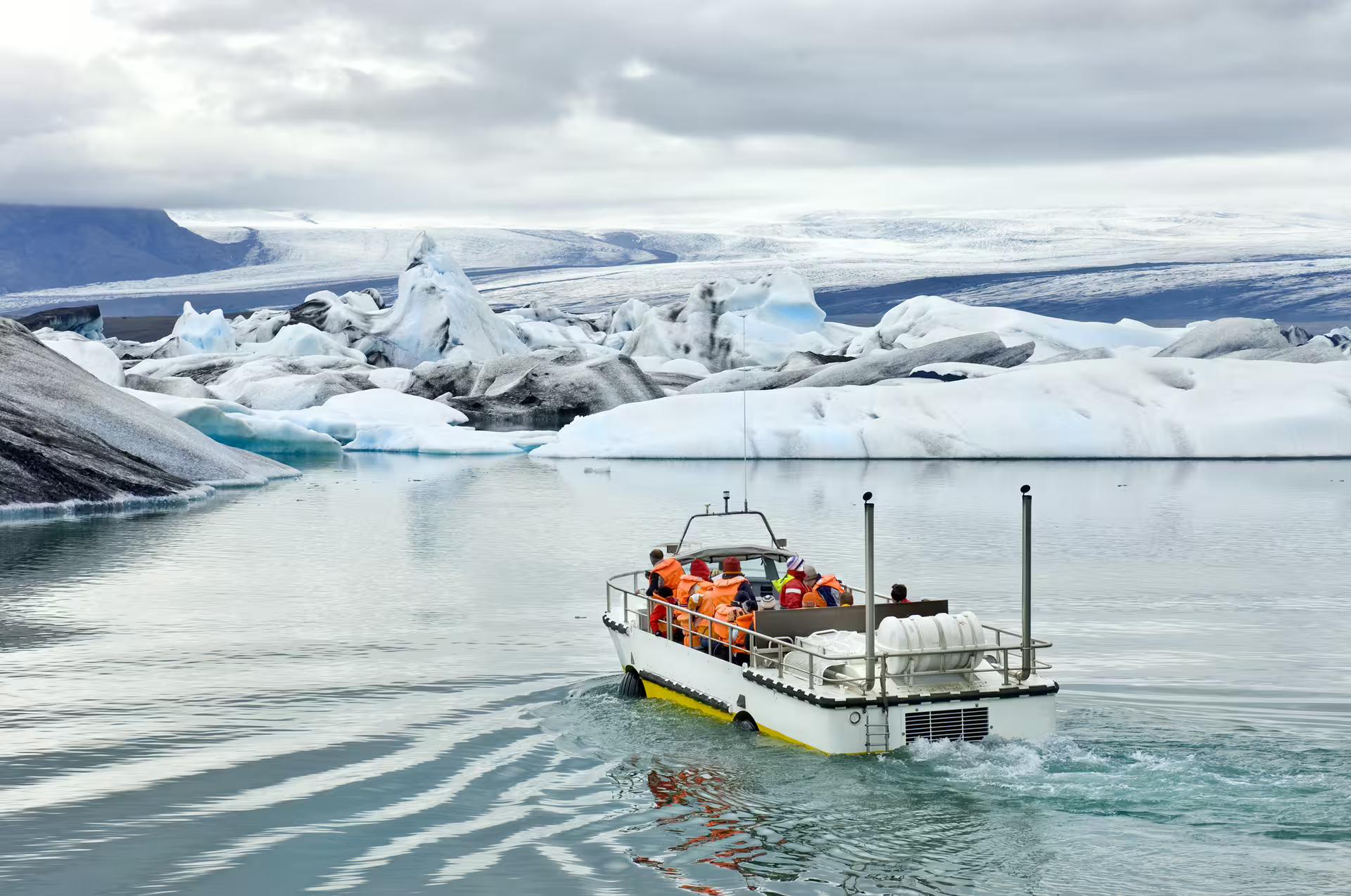 A tour group on board of a amphibious vehicle travelling across the glacier lagoon at Jokulsarlon