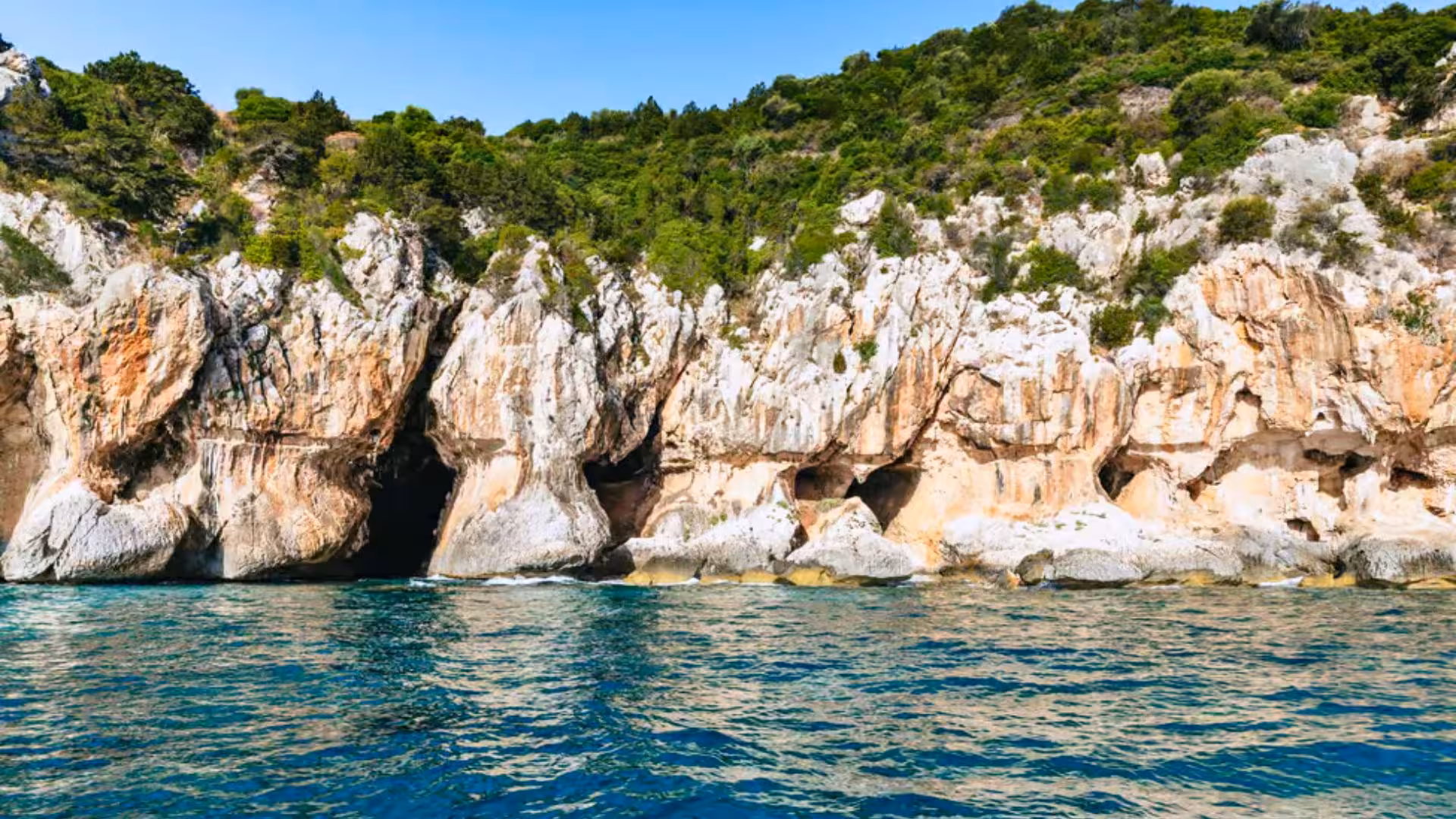Stunning rocky cliffs and lush greenery line the turquoise waters of the Gulf of Orosei, ideal for dinghy exploration.