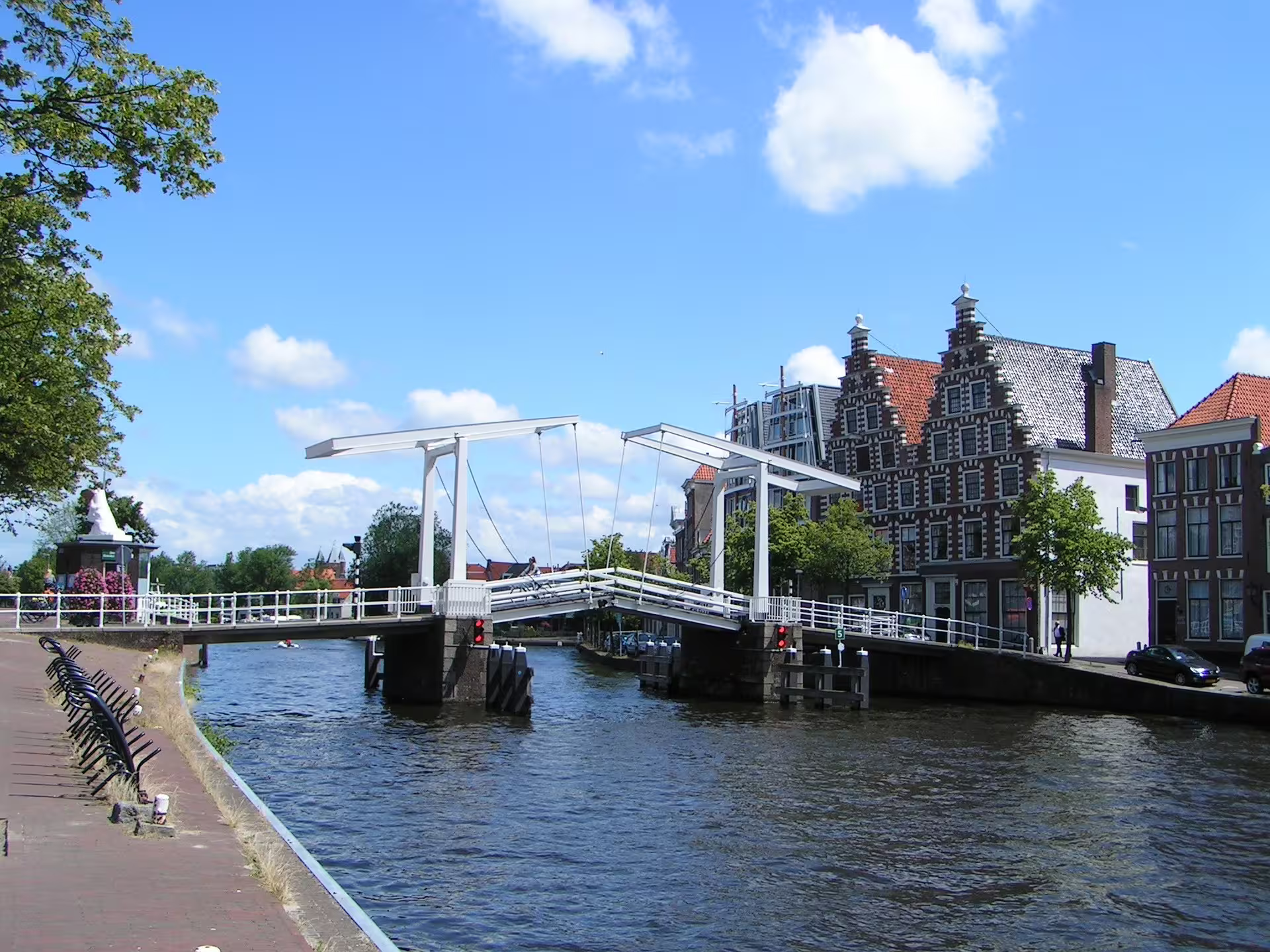 White drawbridge over Haarlem canal beside classic Dutch gabled buildings on a self-guided audio walking tour