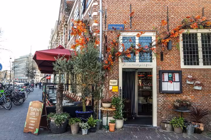 Cozy Haarlem street café on brick corner with bikes and plants, stop on a 2-hour private walking tour