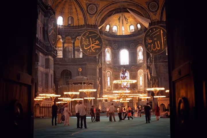 Hagia Sophia interior with chandeliers and Islamic calligraphy, highlight of an all-inclusive Istanbul tour