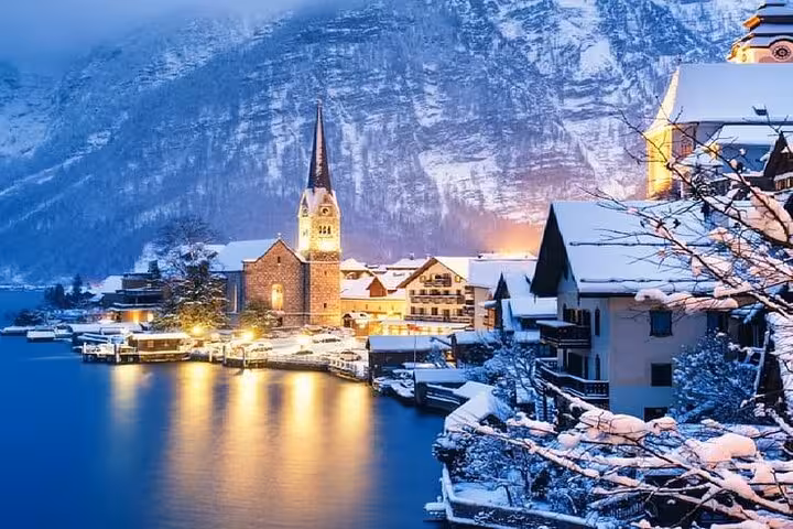 Winter night view of Hallstatt lakeside village and church spire, a highlight of Salzburg private day tour to Bad Ischl