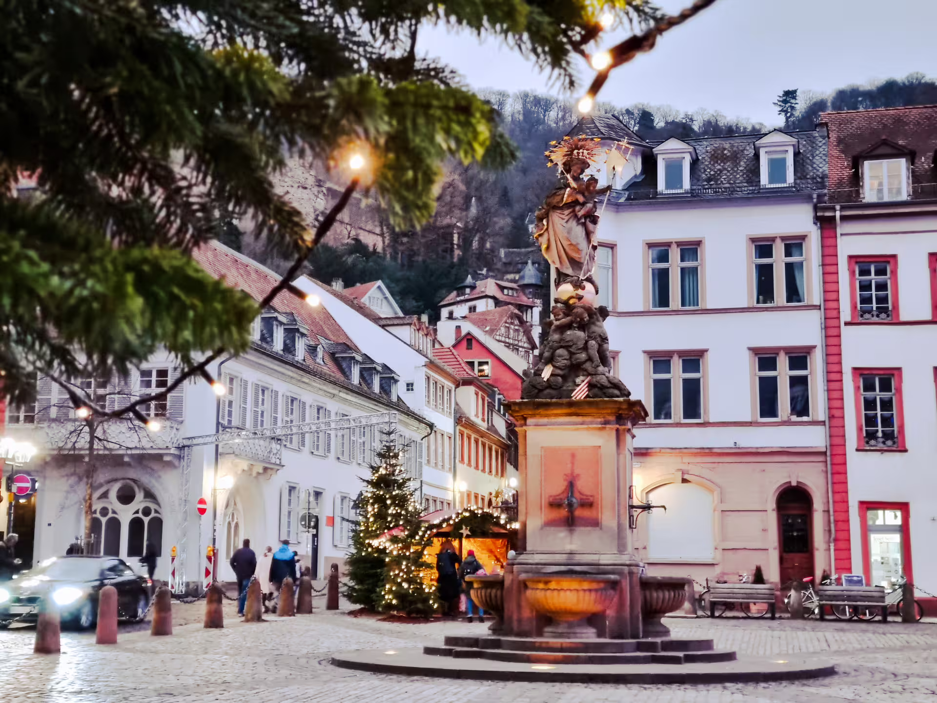 Christmas-lit square in Heidelberg Old Town by Kornmarkt fountain, featured on 1-day walking tour audioguide