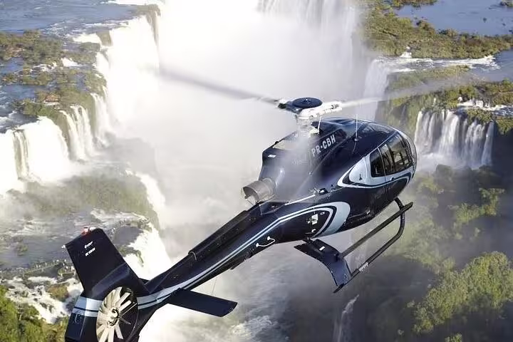 Helicopter soars over Iguaçu Falls, offering panoramic aerial views of the majestic waterfalls and surrounding landscape.
