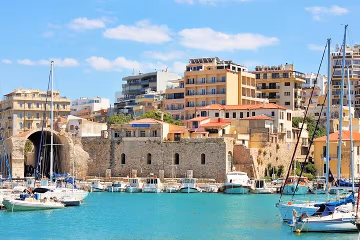 Heraklion Venetian harbor with boats and fortress walls, scenic stop on Knossos & Heraklion day tour from Rethimno