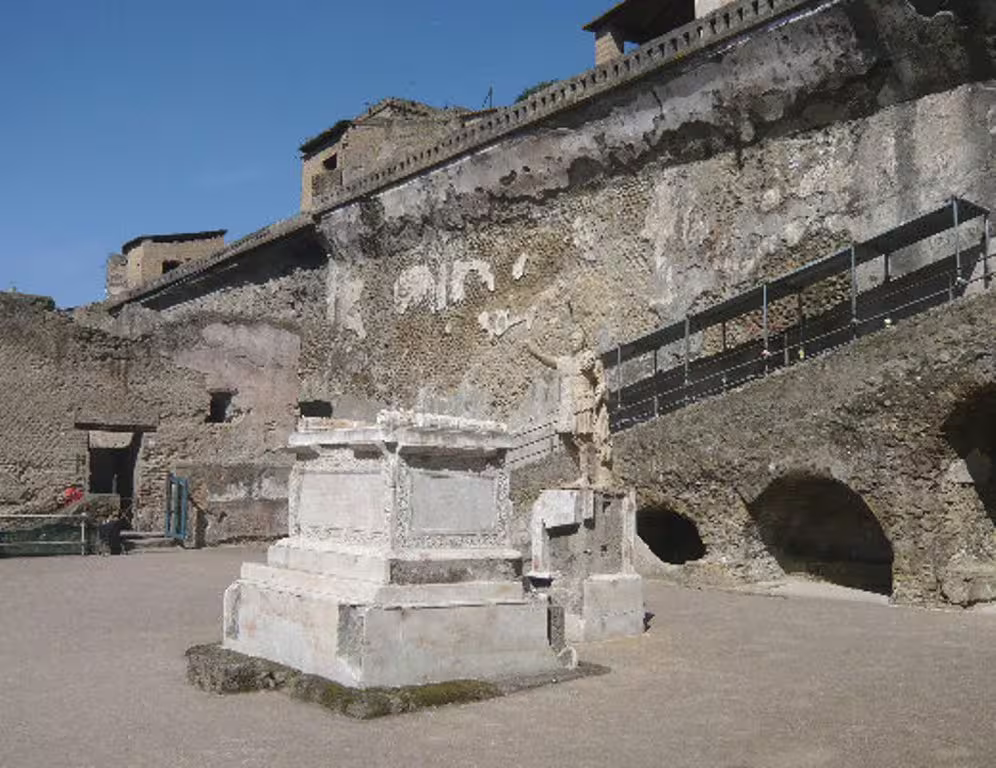 Archaeological site of Herculaneum with preserved stone altar and cliffside ruins included in Pompei Ercolano tour