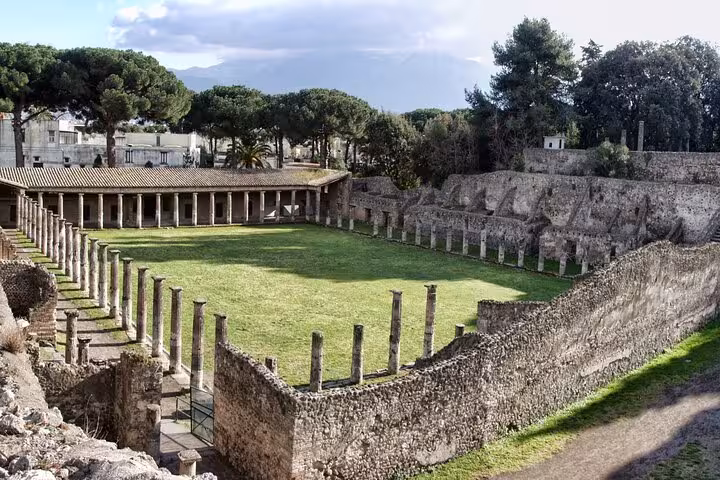 View of ancient ruins and green courtyard in Herculaneum, perfect for skip-the-line tours to explore history effortlessly.