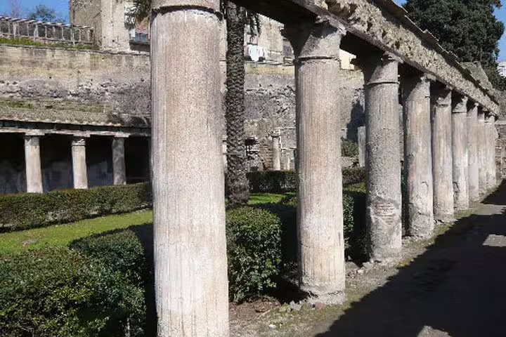 Ancient columned walkway and manicured gardens at Herculaneum archaeological site on a guided private half-day ruins tour