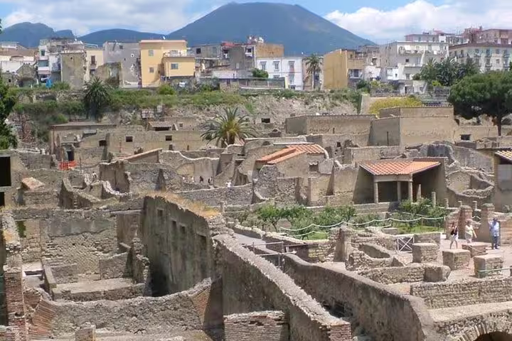 Panoramic view of Herculaneum ruins with Mount Vesuvius and Ercolano town on a sunny private half-day archaeological tour