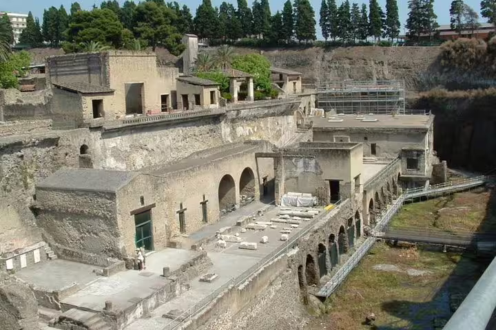 Archaeological remains of Herculaneum’s terraced villas and walkways seen on a guided day trip from Pompeii and Vesuvius