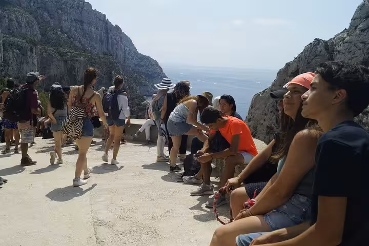 Hikers resting at a Calanques viewpoint above the Mediterranean on a Marseille guided hiking tour