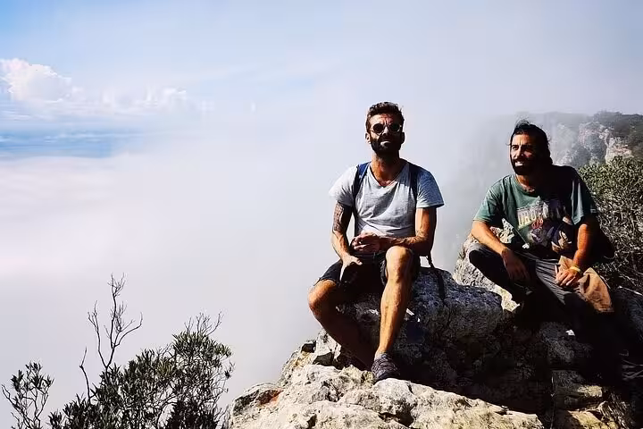 Hikers resting on cliff edge at Capo Caccia, Sardinia, on hike to continental Europe’s highest sea cliff viewpoint