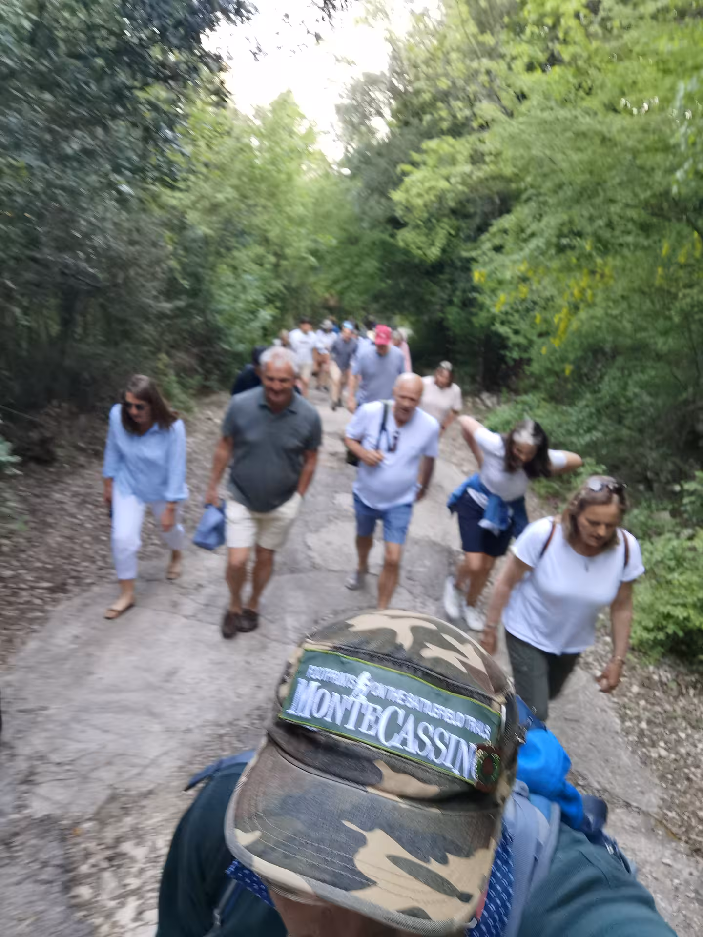 Group of hikers enjoying a lush green trail at L'Anello della Collina Imprendibile, perfect for nature enthusiasts.