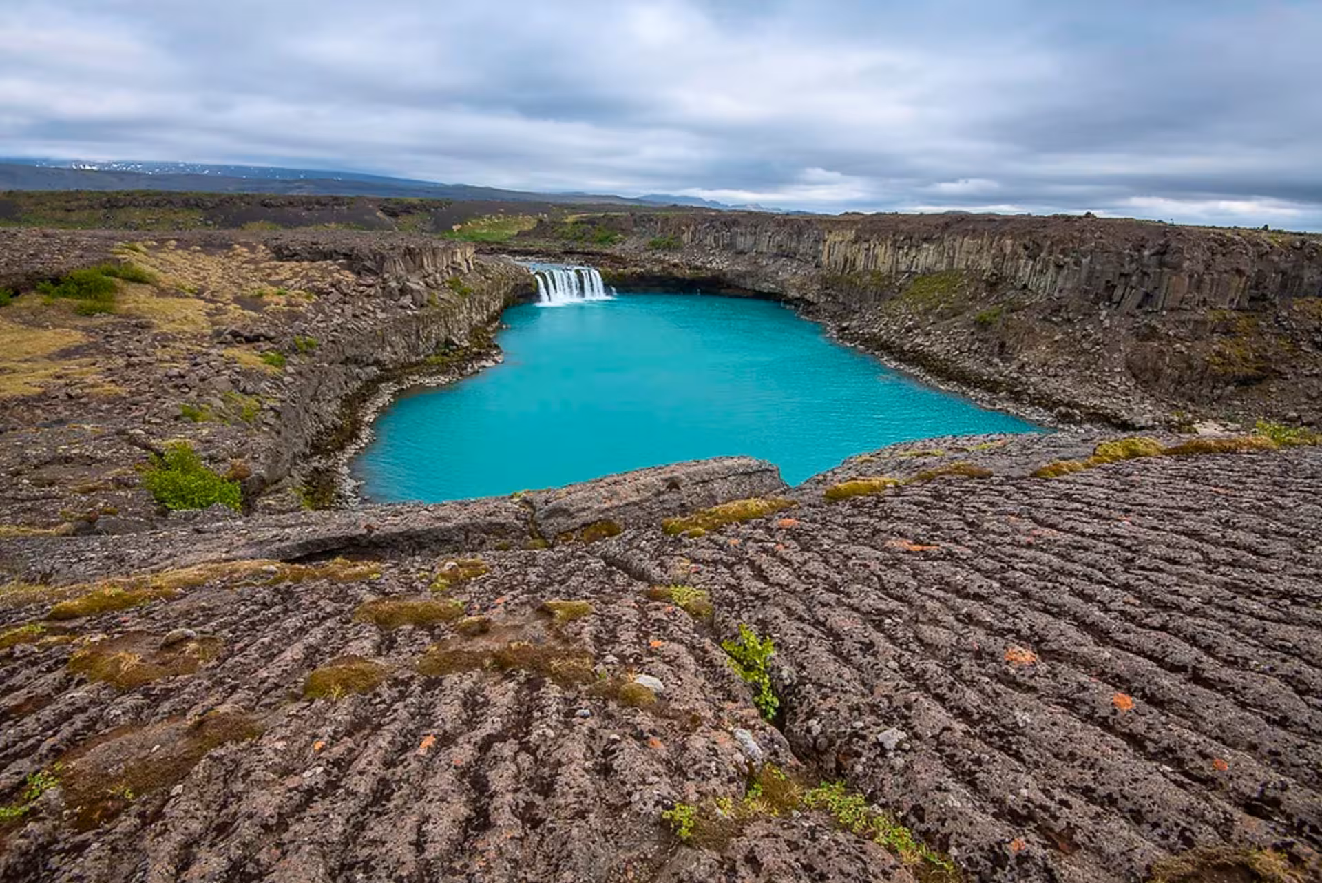 Turquoise Hjalparfoss pool and lava fields in Þjórsárdalur Valley, Iceland, on a private guided tour