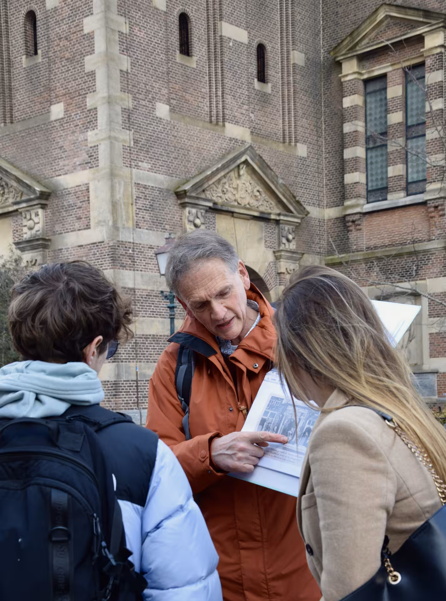 Private Hoorn walking tour guide explains historic highlights with map outside a landmark brick church